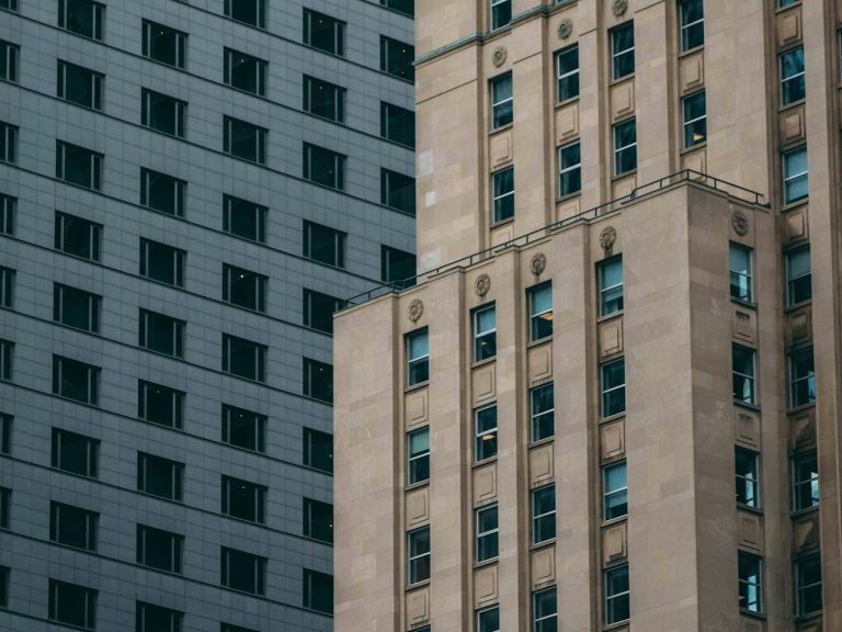 Close-up of contrasting architectural styles with textured stone and dark geometric patterns.